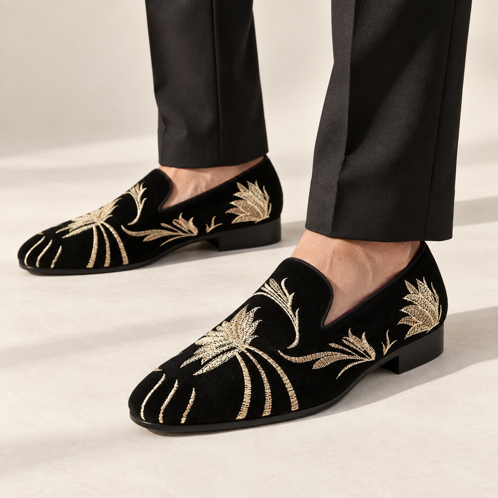 Alessio loafers in black with gold embroidery, worn with tailored trousers.