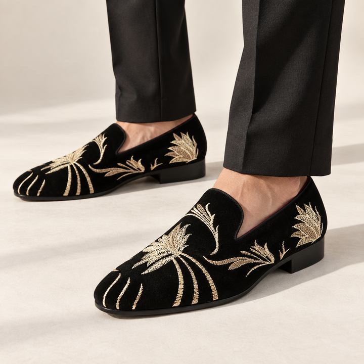 Alessio loafers in black with gold embroidery, worn with tailored trousers.