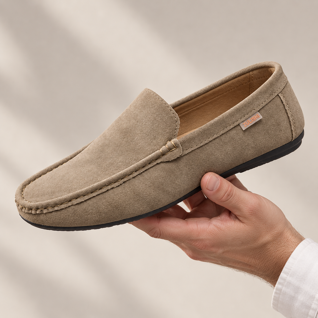 Ellis loafers in khaki, held in a hand.