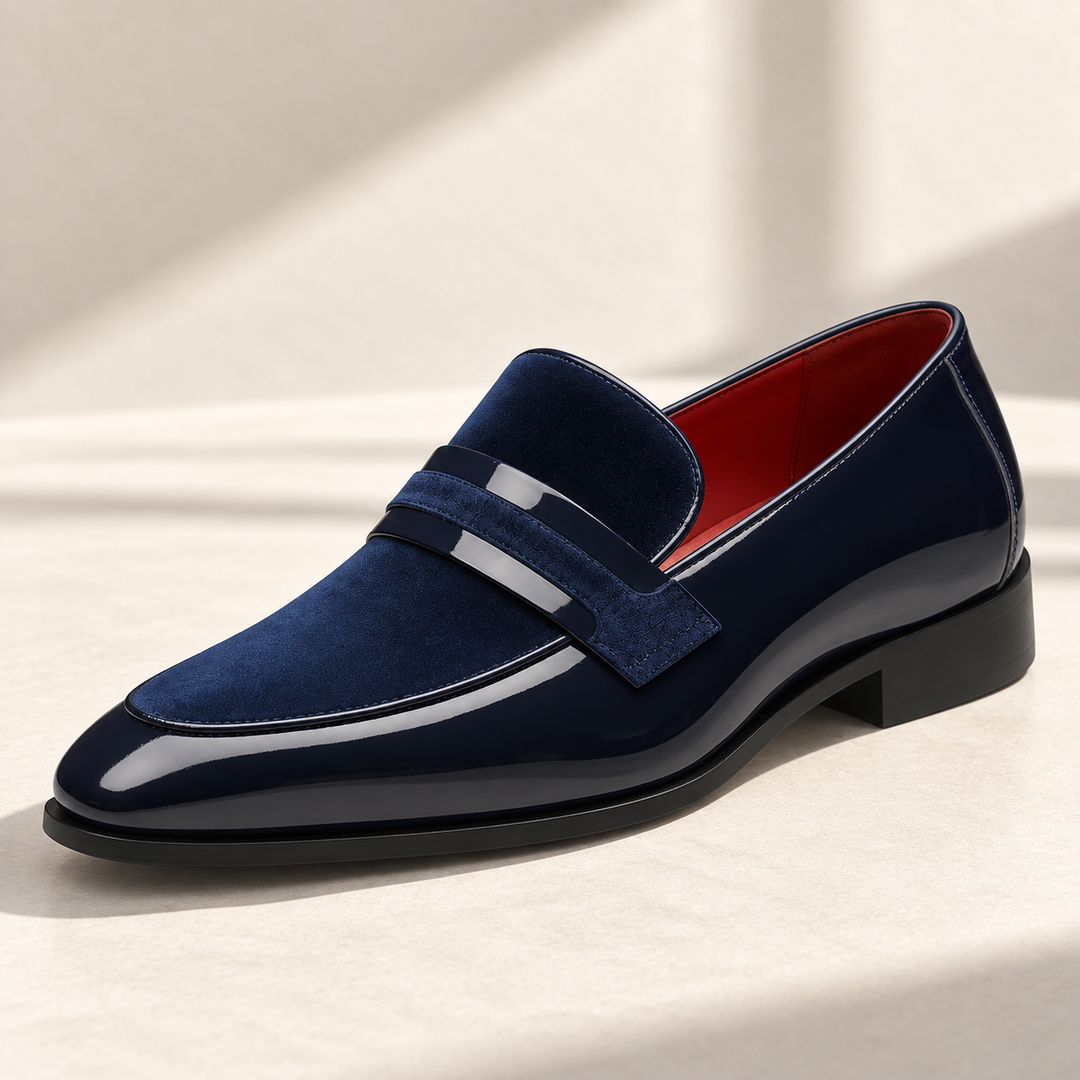 Enzo loafers in navy, photographed on a warm neutral studio background.