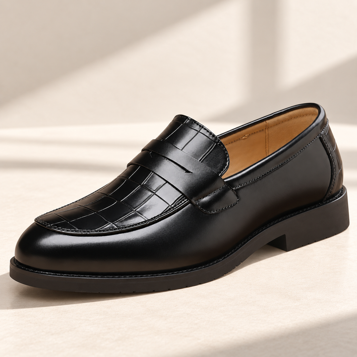 Kensington loafers in black, photographed on a warm neutral studio background.