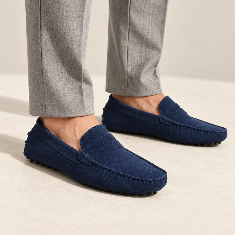 Lucca loafers in navy blue, worn with tailored trousers.