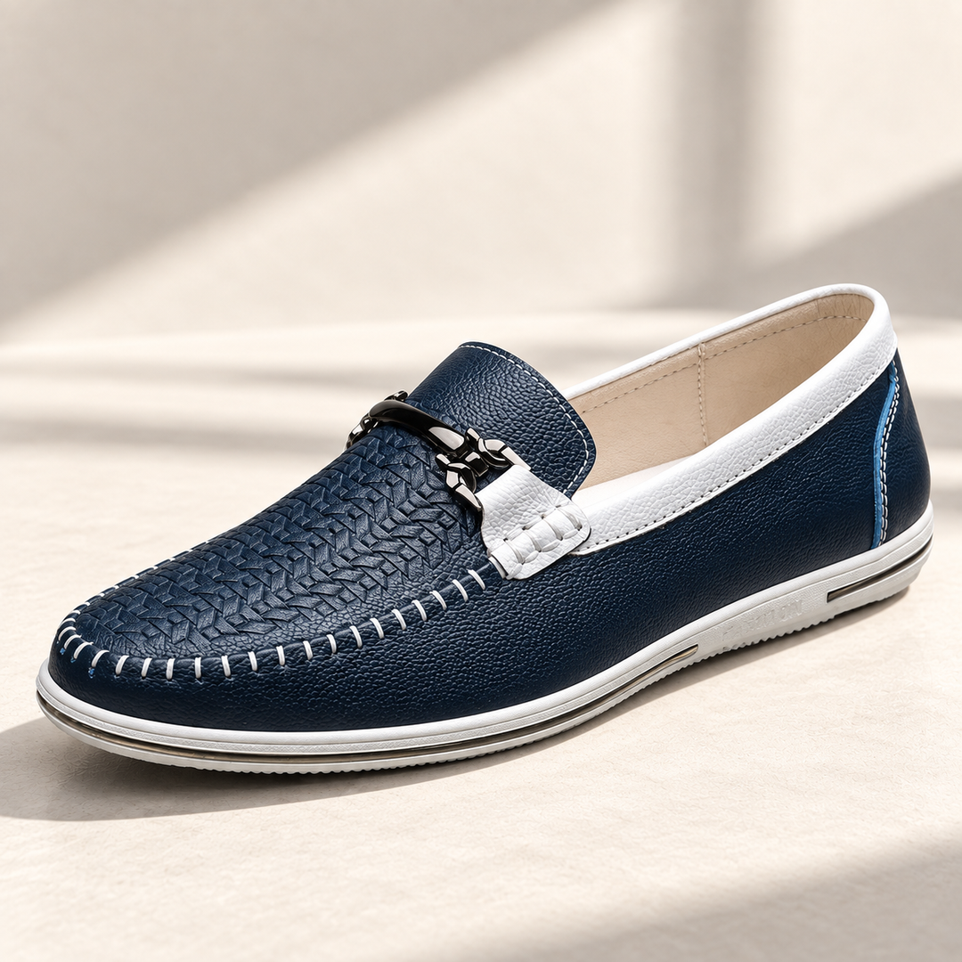 Milo loafers in navy and white, photographed on a warm neutral studio background.