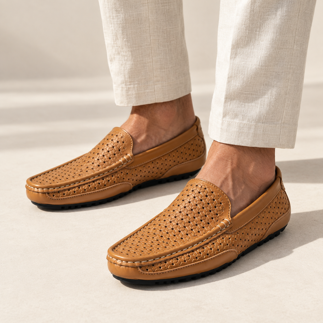 Ravello loafers in perforated tan, worn with tailored trousers.