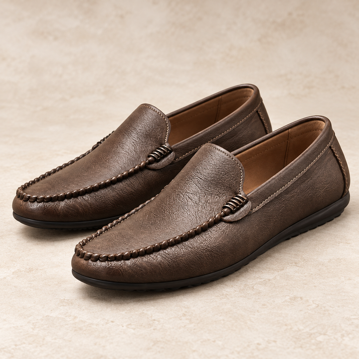 Ronan brown moc-toe loafers with braided vamp detail and dark soles, photographed as a pair in a warm neutral studio.