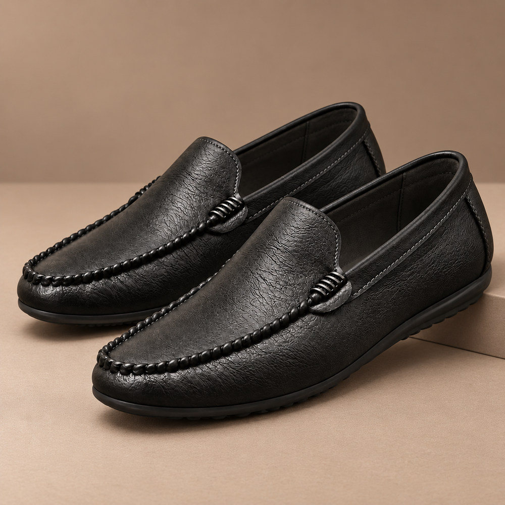 Ronan Genuine Leather Slip-On Loafers in black, photographed in a warm taupe studio