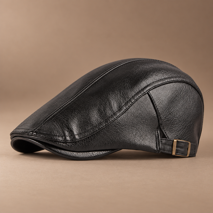 Heritage Leather Driving Cap in coal black, photographed in a warm taupe studio
