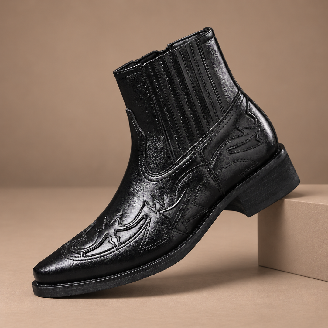 Nollan Genuine Leather Embossed Boots in black, photographed in a warm taupe studio