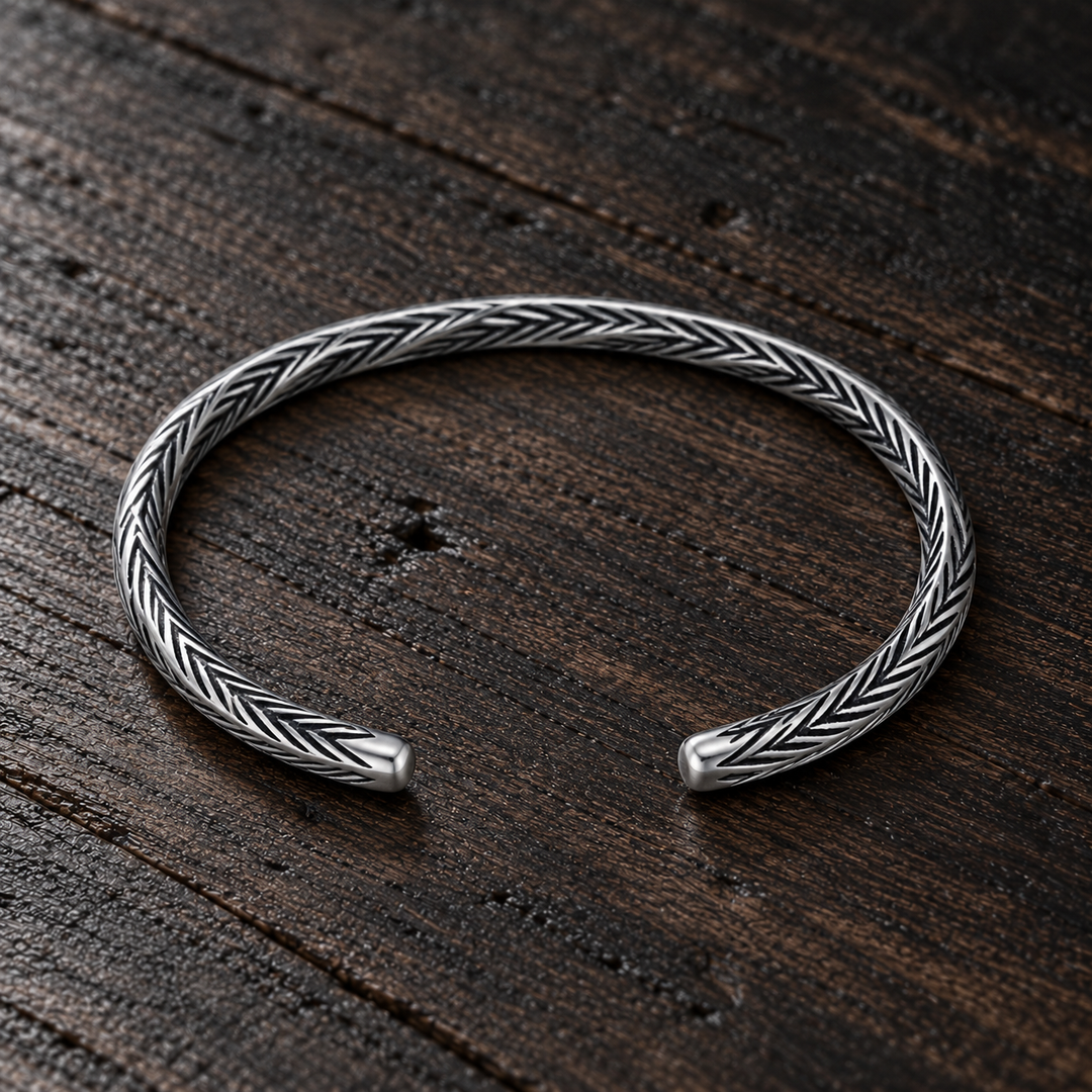 The Camden B-512S sterling silver engraved cuff resting flat on dark wood, with its open ends visible