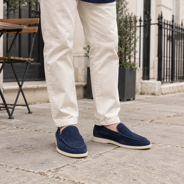 Navy Blue Sloane loafers worn with cream chinos outside a British cafe